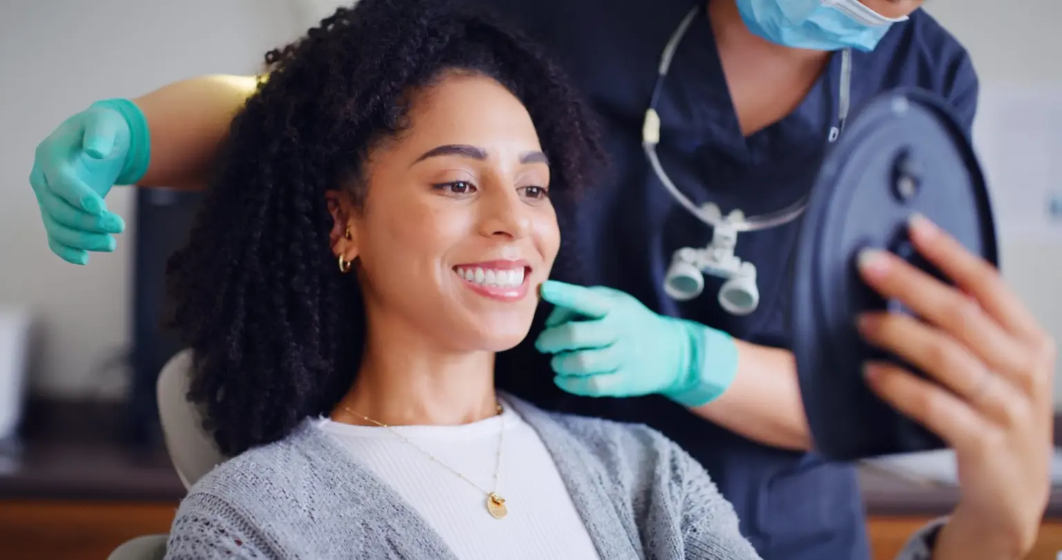 young woman smiling in a dental chair, routine dental cleaning
