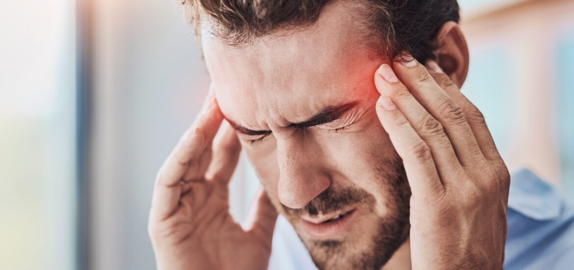 man with a headache massaging his temples