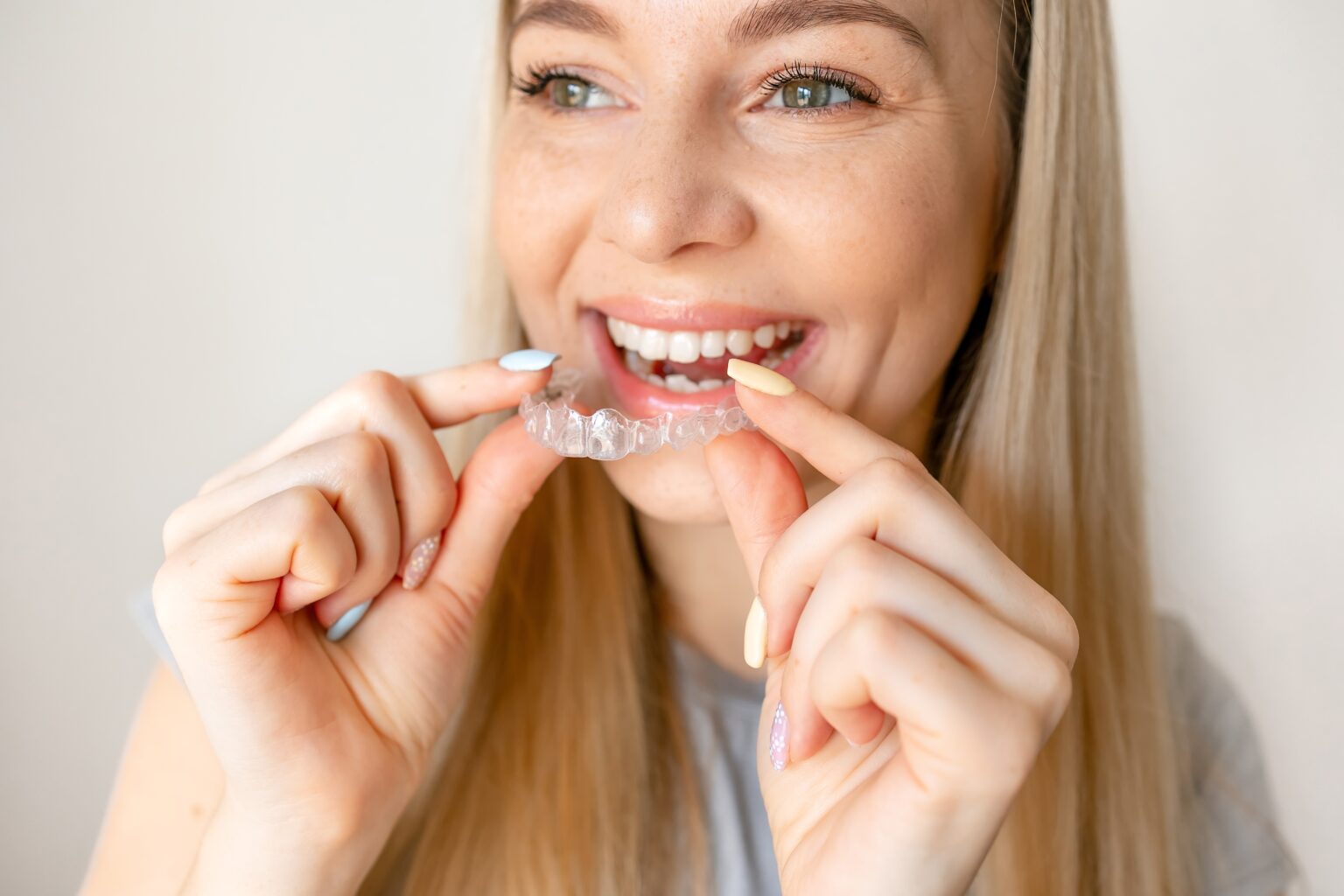 closeup young woman placing in her clear aligners